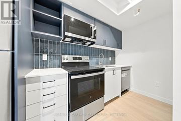 Hamilton (Corktown) multi-family for rent - A modern kitchen with stainless steel appliances and white cabinets.