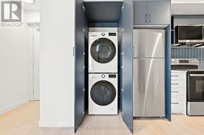 Hamilton (Corktown) multi-family for rent - A modern kitchen with a washer and dryer built into the cabinetry.