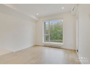 Surrey apartment for rent - A spacious room with a large window and wooden flooring.