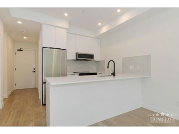 Surrey apartment for rent - A modern kitchen with white cabinets and a stainless steel refrigerator.
