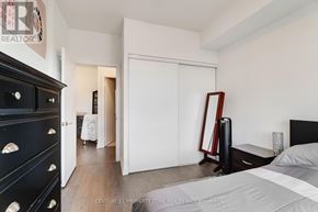 Toronto (Mimico) condo for rent - A bedroom with a black dresser and a white bed.