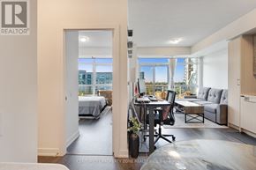 Toronto (Mimico) condo for rent - A well-lit, modern living room with a view of the cityscape outside the window.