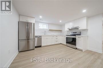 Niagara Falls (Hospital) apartment for rent - A kitchen with white cabinets and a stainless steel refrigerator.