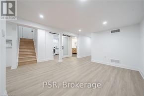 Niagara Falls (Hospital) apartment for rent - A spacious room with wooden flooring and white walls, with a staircase on the left side.