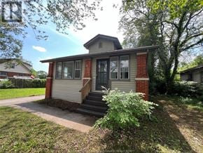Windsor apartment for rent - A small house with a red brick chimney and a grey roof.