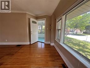 Windsor apartment for rent - A room with wooden floors and a door leading to a balcony.