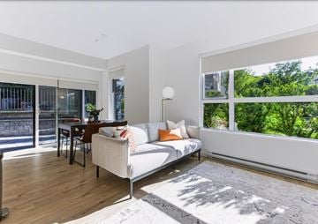 Abbotsford apartment for rent - A living room with a white couch and a grey rug.
