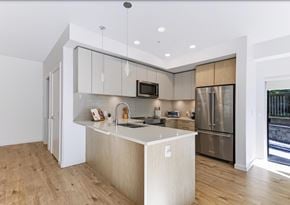 Abbotsford apartment for rent - A modern kitchen with a wooden floor and stainless steel appliances.