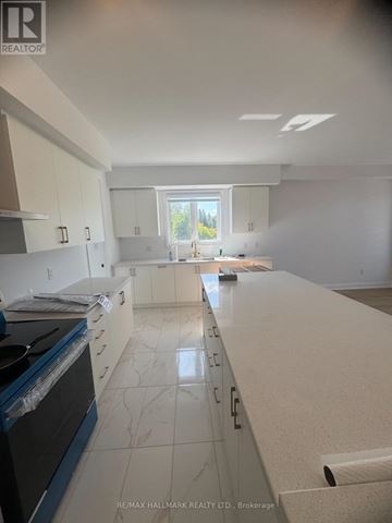 Barrie apartment for rent - A kitchen with white cabinets and a black stove top oven.