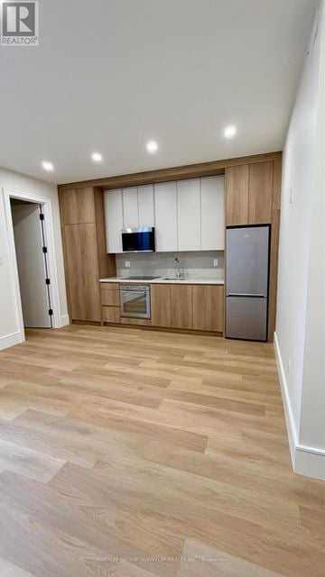 Mississauga (Port Credit) apartment for rent - A kitchen with wooden cabinets and a refrigerator.