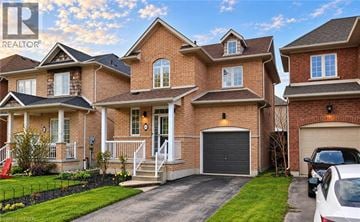 Stoney Creek apartment for rent - A large, multi-story brick house with a garage and a car parked in front.