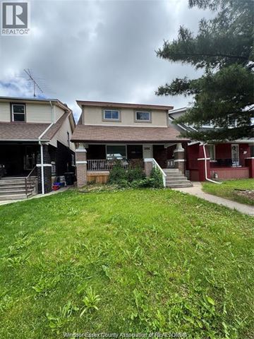 Windsor apartment for rent - A grassy yard in front of a house with a sign that says REALTOR.