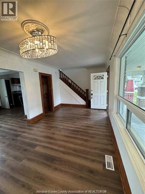 Windsor apartment for rent - A chandelier hangs over a wooden floor in a room with a staircase.