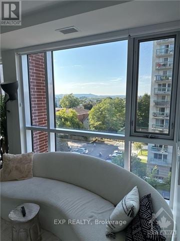 Ottawa condo for rent - A living room with a couch and a window overlooking a street.