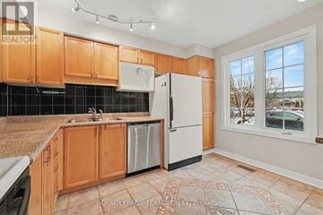Ottawa townhouse for rent - A kitchen with wooden cabinets and a black tile backsplash.
