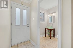 Ottawa townhouse for rent - A white door with a glass panel is on the left and a small table with a green cloth on it is in the middle of the room.