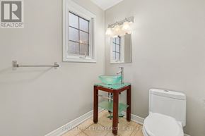 Ottawa townhouse for rent - A white toilet sits next to a sink in a small bathroom.