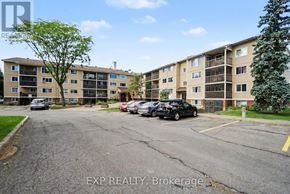 Ottawa condo for rent - A parking lot in front of apartment buildings with cars parked.