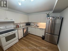 Ottawa townhouse for rent - A kitchen with white cabinets and a stainless steel refrigerator.