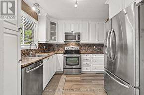 Ottawa townhouse for rent - A kitchen with white cabinets and stainless steel appliances.