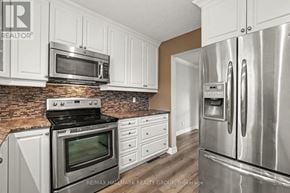 Ottawa townhouse for rent - A kitchen with white cabinets and a brick backsplash.