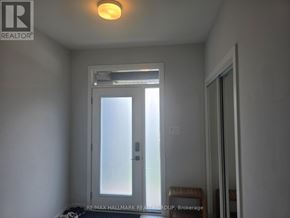 Ottawa townhouse for rent - A white door with a glass window is in a room with a light on the ceiling.