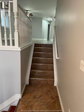 Windsor apartment for rent - A staircase with a white railing and brown tiles.
