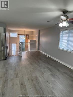 Windsor apartment for rent - A spacious room with a ceiling fan and light, hardwood floors, and a doorway leading to another room.