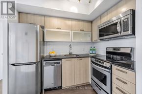 Toronto (Little Portugal) condo for rent - A modern kitchen with stainless steel appliances and wooden cabinets.