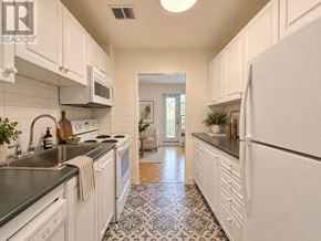 Toronto (St. Andrew-Windfields) condo for rent - A kitchen with white cabinets and a black and white floor.