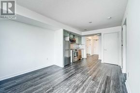Toronto (Waterfront Communities) condo for rent - A spacious room with wooden flooring and white walls.
