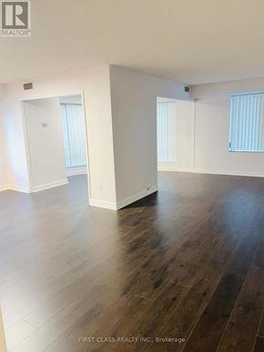 Toronto (Waterfront Communities) condo for rent - A room with wooden floors and white walls.