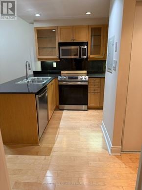 Toronto (Annex) condo for rent - A kitchen with wooden cabinets and black appliances.