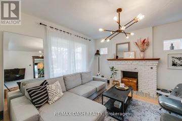 Toronto (Woodbine-Lumsden) apartment for rent - A living room with a grey couch and a fireplace.