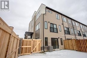 Innisfil (Lefroy) townhouse for rent - A modern two-story residential building with a wooden fence in front.