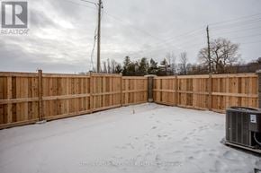 Innisfil (Lefroy) townhouse for rent - A backyard with a wooden fence and a snow-covered ground.