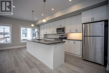 Innisfil (Lefroy) townhouse for rent - A modern kitchen with white cabinets and a stainless steel refrigerator.