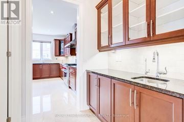 King (Nobleton) apartment for rent - A kitchen with brown cabinets and a marble countertop.
