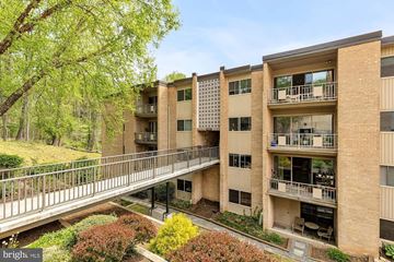 Rockville apartment for rent - A bridge connects two buildings in a courtyard with bushes and trees.