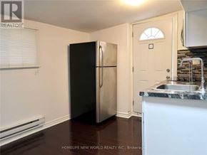 Toronto (Corso Italia-Davenport) apartment for rent - A black refrigerator in a kitchen with a white door.