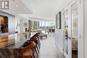 Toronto (Waterfront Communities) condo for rent - A modern kitchen with a bar area and a view of the backyard.