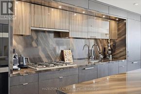 Toronto (Waterfront Communities) condo for rent - A modern kitchen with a stainless steel countertop and wooden cabinets.