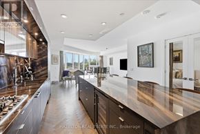 Toronto (Waterfront Communities) condo for rent - A modern kitchen with a long island and a view of the backyard.
