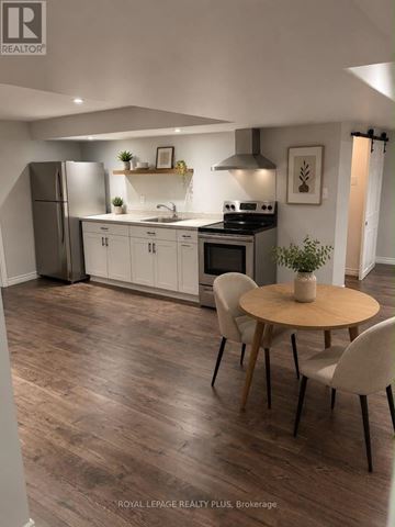 Hamilton (Stoney Creek) apartment for rent - A modern kitchen with a wooden table and chairs.