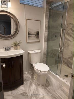 Hamilton (Stoney Creek) apartment for rent - A white toilet in a bathroom with a glass shower door.