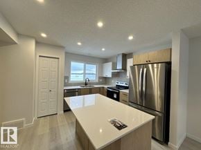 Edmonton apartment for rent - A kitchen with a refrigerator, sink, and cabinets.