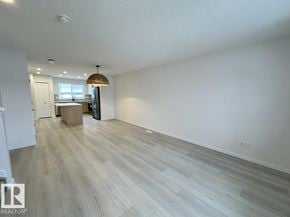 Edmonton apartment for rent - A large empty room with light wood flooring and a white ceiling.