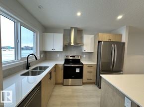 Edmonton apartment for rent - A kitchen with a stove, sink, and refrigerator.