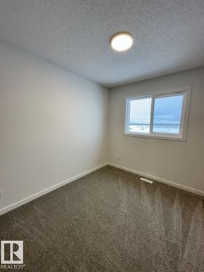 Edmonton apartment for rent - A room with a carpeted floor and a window overlooking the beach.