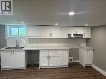 Hamilton apartment for rent - A kitchen with white cabinets and a marble countertop.